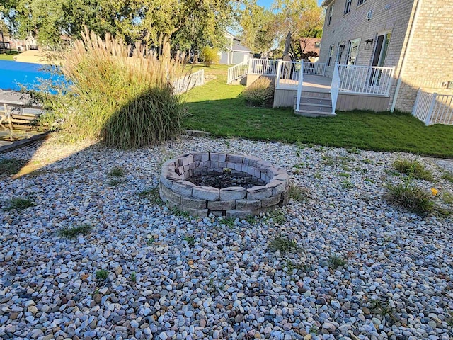 view of yard featuring a deck and a fire pit