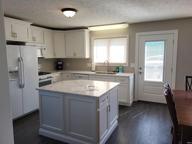 kitchen with dark hardwood / wood-style flooring, white appliances, white cabinetry, and sink