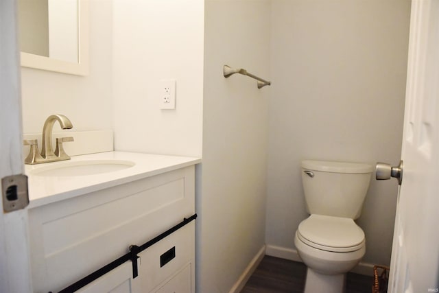 bathroom with hardwood / wood-style floors, vanity, and toilet