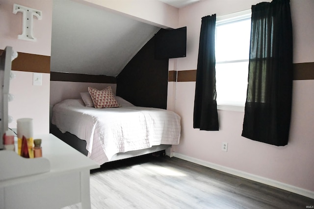 bedroom with wood-type flooring and lofted ceiling