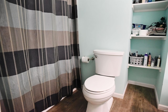 bathroom featuring a shower with shower curtain, hardwood / wood-style floors, and toilet