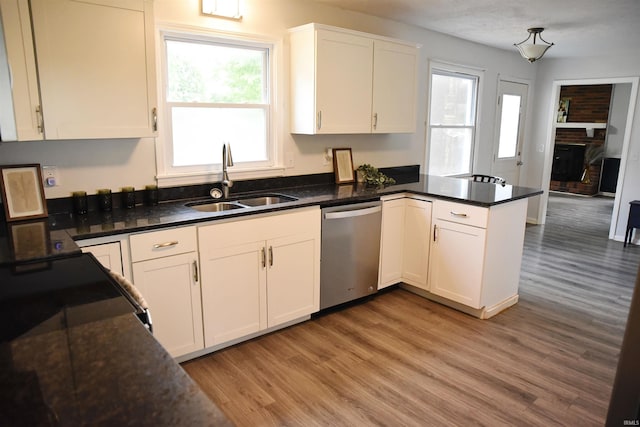 kitchen with dishwasher, light wood-type flooring, sink, and kitchen peninsula