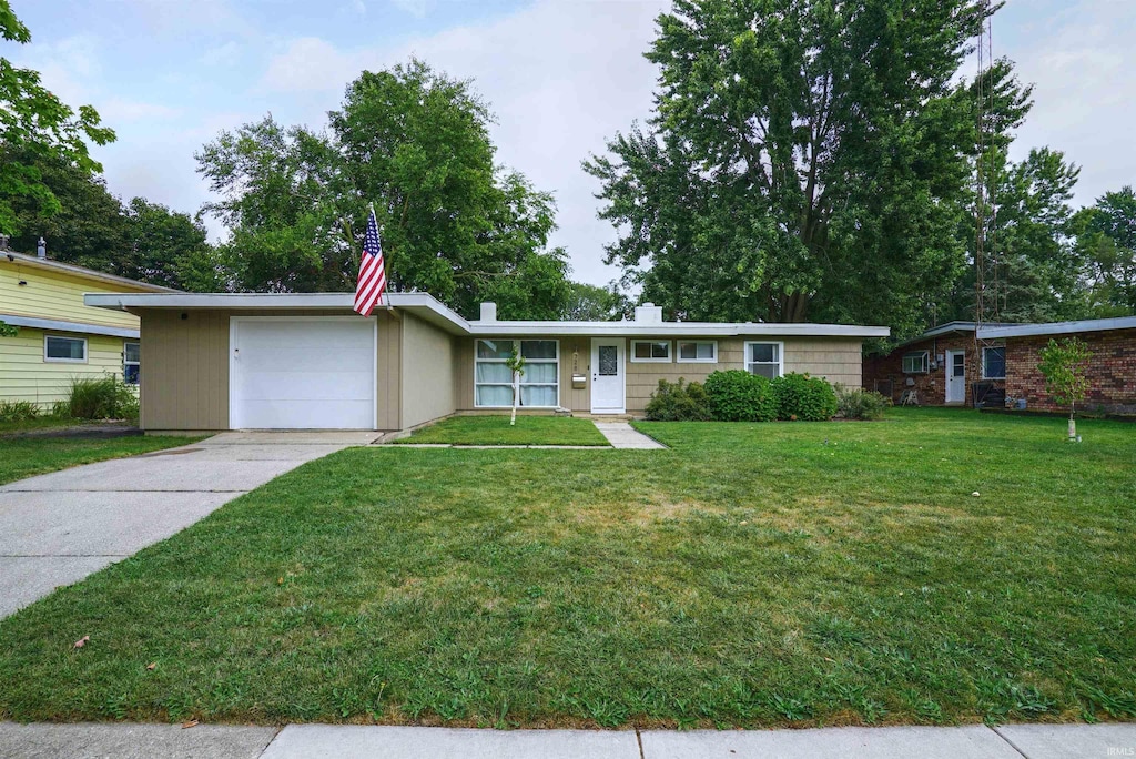 ranch-style house featuring a garage and a front lawn