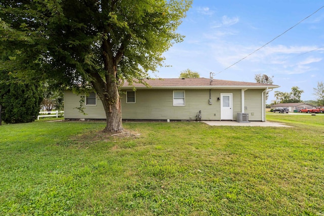 back of house with central AC, a patio area, and a yard