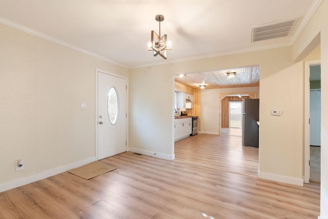 entrance foyer featuring a notable chandelier, light wood-type flooring, and ornamental molding