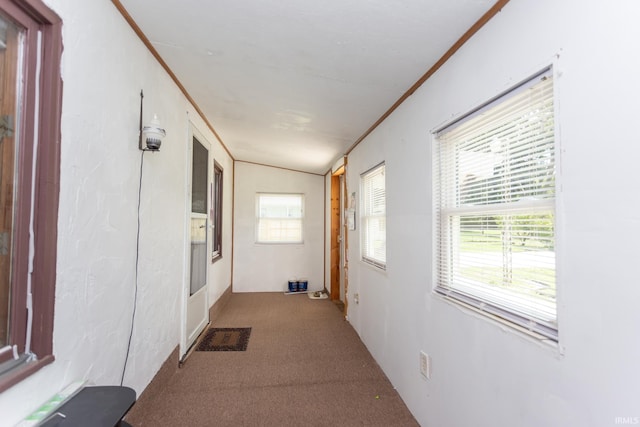 corridor featuring light carpet, vaulted ceiling, and crown molding