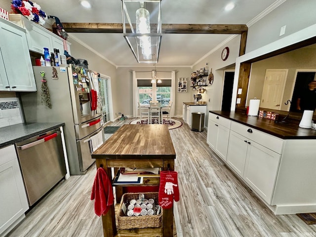 kitchen featuring hanging light fixtures, light hardwood / wood-style floors, dishwasher, and wood counters