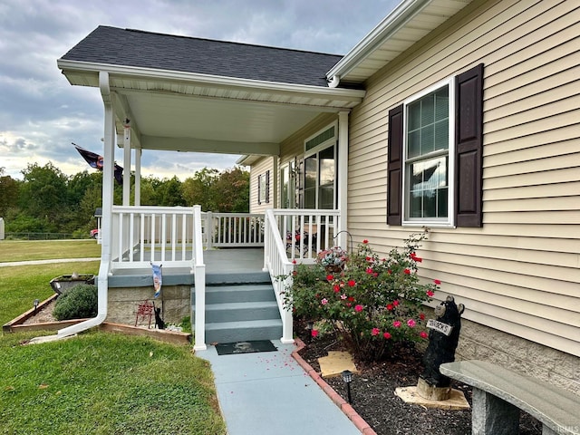 entrance to property featuring a yard and a porch