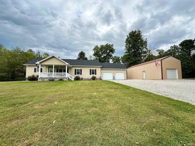 view of front of property featuring a front lawn, covered porch, an outdoor structure, and a garage