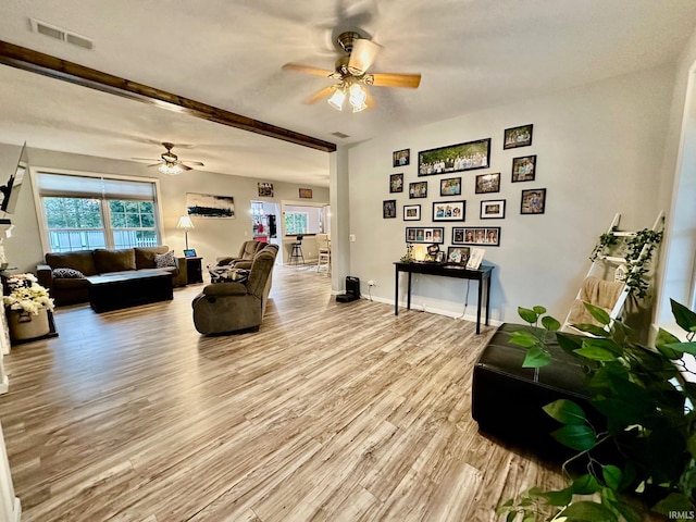 living room with light wood-type flooring, beam ceiling, and ceiling fan