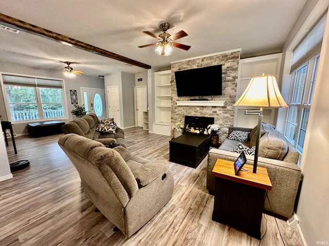 living room featuring ceiling fan, hardwood / wood-style flooring, and a fireplace