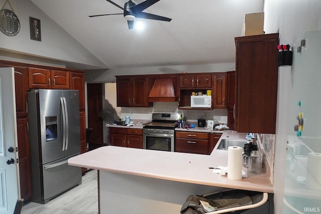 kitchen featuring light wood-type flooring, tasteful backsplash, vaulted ceiling, kitchen peninsula, and stainless steel appliances