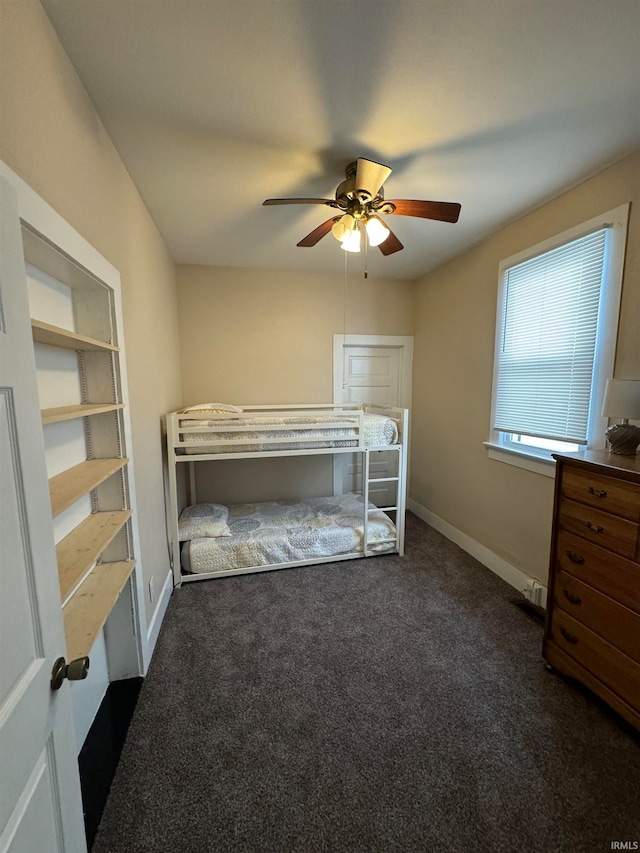 unfurnished bedroom featuring ceiling fan and dark colored carpet