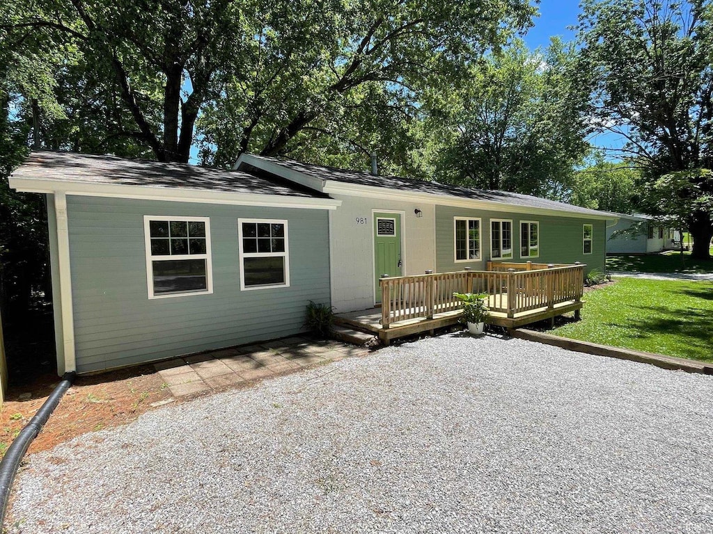 single story home featuring a deck and a front lawn