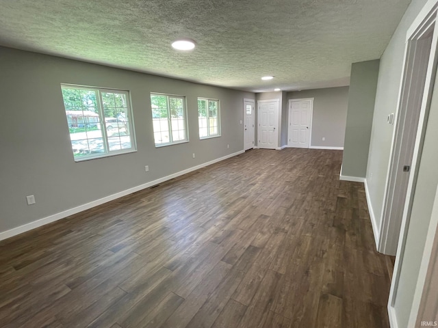 spare room featuring a textured ceiling and dark wood-type flooring