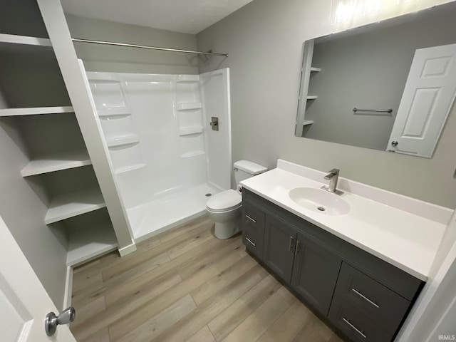 bathroom featuring walk in shower, vanity, toilet, and hardwood / wood-style flooring