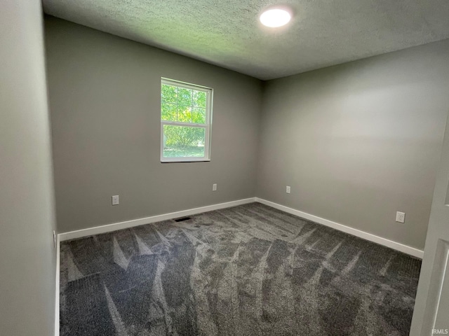 spare room with a textured ceiling and carpet floors