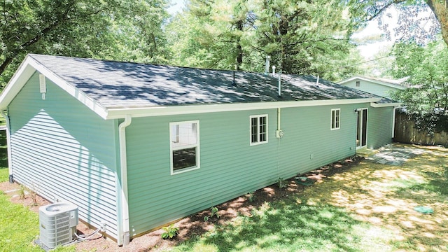 view of side of property featuring cooling unit and a yard