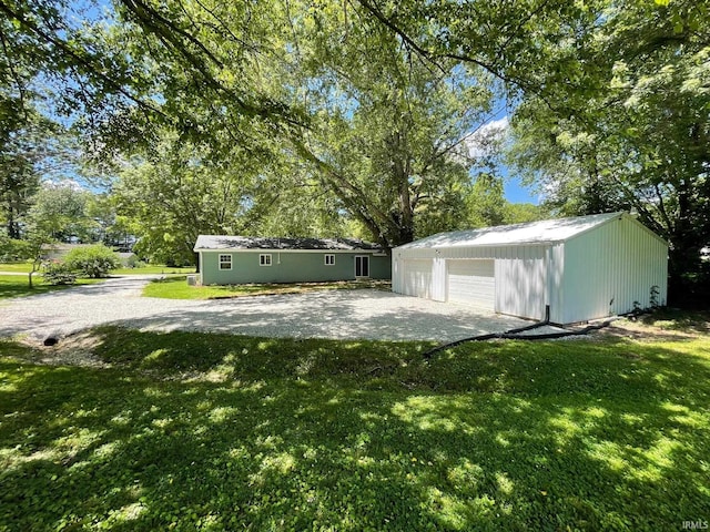 view of yard featuring a garage and an outbuilding