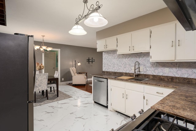 kitchen featuring white cabinets, pendant lighting, stainless steel appliances, an inviting chandelier, and sink