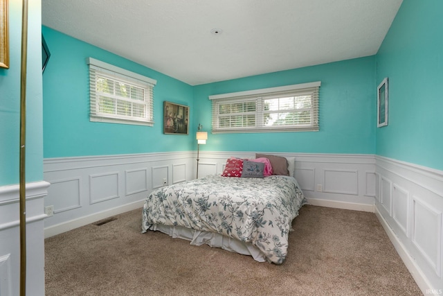 bedroom with multiple windows and carpet floors