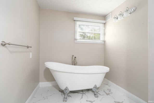 bathroom with a textured ceiling and a bathing tub