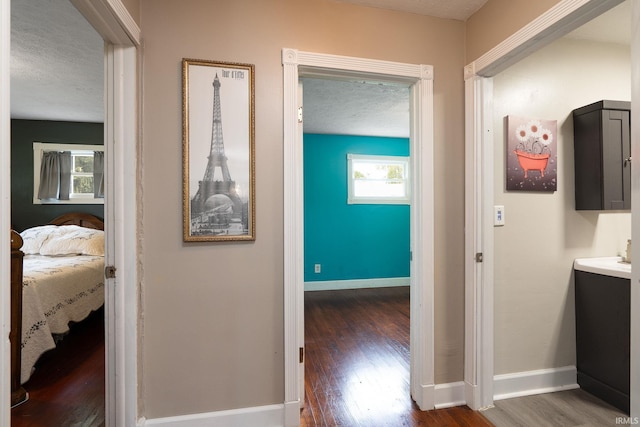 hallway featuring a textured ceiling and dark hardwood / wood-style flooring