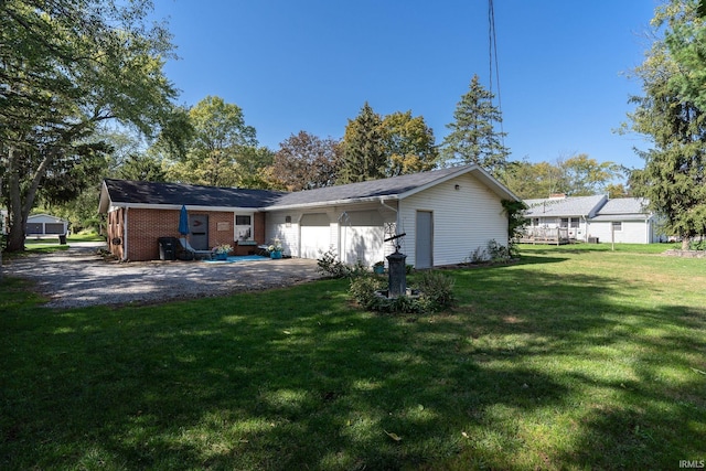 rear view of house featuring a lawn and a garage