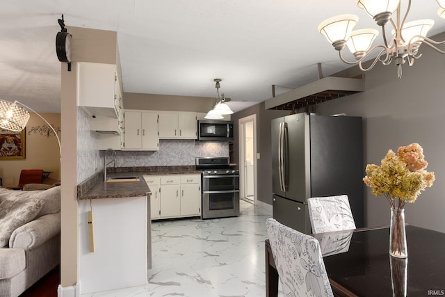 kitchen featuring tasteful backsplash, sink, white cabinets, hanging light fixtures, and appliances with stainless steel finishes