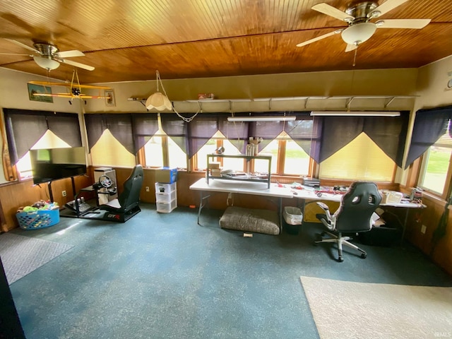 misc room featuring wooden walls, built in desk, ceiling fan, and wooden ceiling