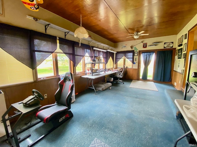 misc room featuring wood ceiling, wooden walls, and ceiling fan