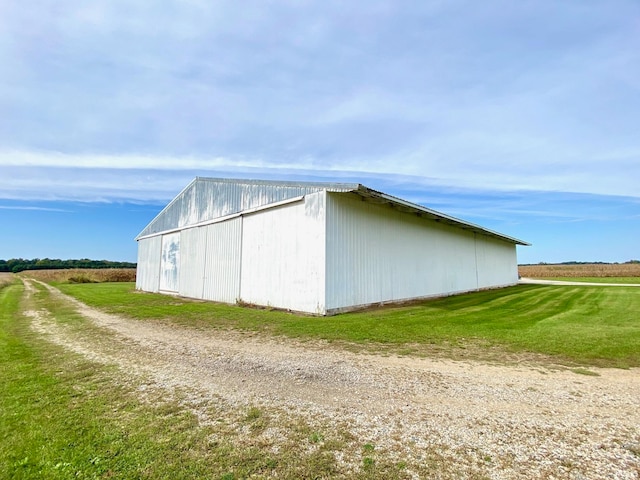 view of side of property featuring a yard and an outbuilding