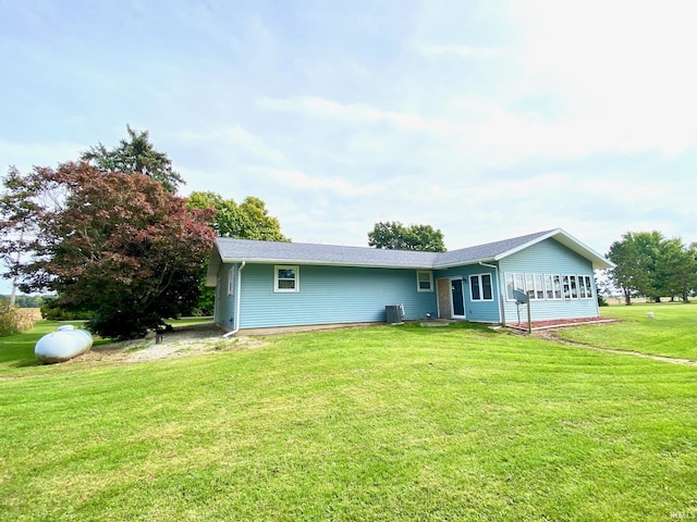 ranch-style house featuring central AC unit and a front yard