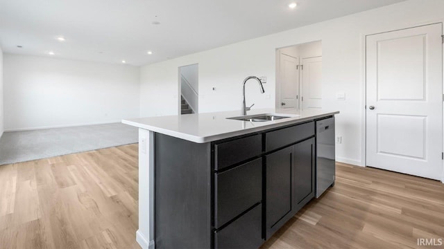 kitchen with light hardwood / wood-style flooring, a center island with sink, stainless steel dishwasher, and sink