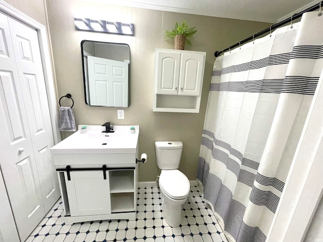 bathroom with a shower with curtain, a textured ceiling, vanity, and toilet