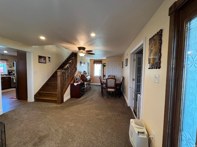 living room with dark carpet, a textured ceiling, and ceiling fan