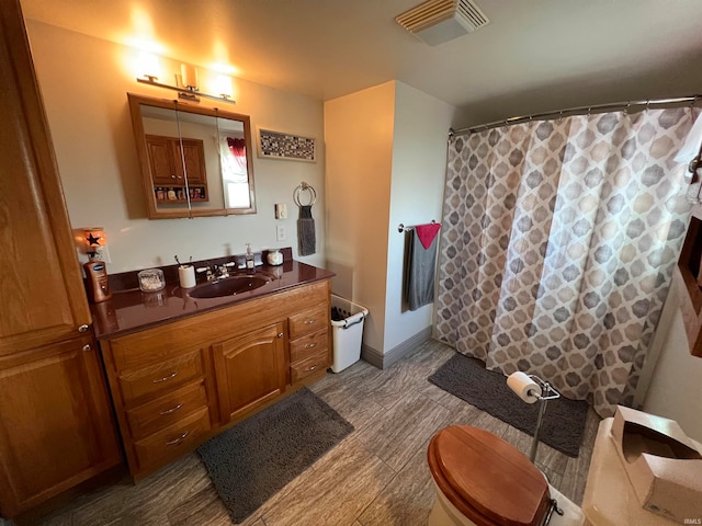 bathroom with hardwood / wood-style floors, curtained shower, vanity, and toilet