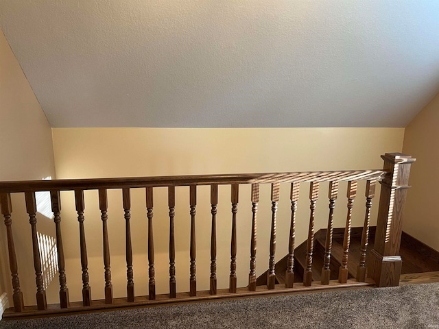 staircase featuring carpet flooring and vaulted ceiling