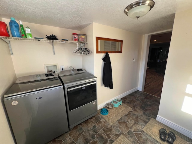 laundry area featuring a textured ceiling, dark hardwood / wood-style floors, and washing machine and clothes dryer