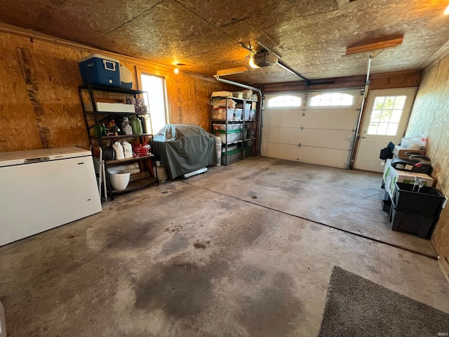 garage with a garage door opener and white refrigerator