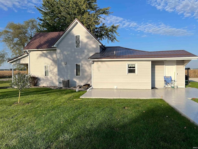 back of house featuring cooling unit, a yard, and a patio area