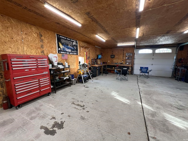 garage with wood walls and a workshop area