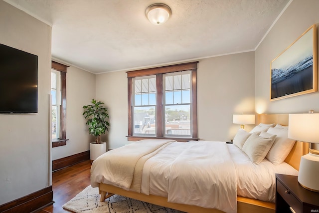 bedroom featuring crown molding and dark wood-type flooring