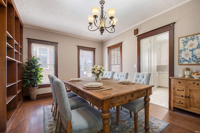 dining room featuring ornamental molding, an inviting chandelier, and dark hardwood / wood-style flooring