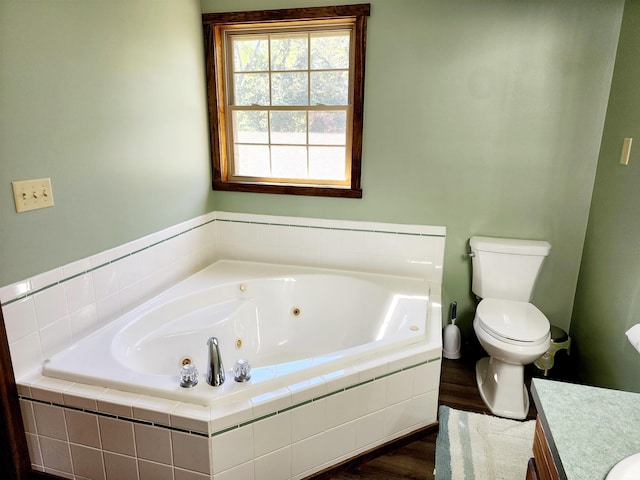 bathroom featuring tiled tub, vanity, toilet, and wood-type flooring