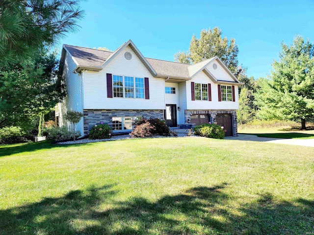 bi-level home featuring a garage and a front lawn