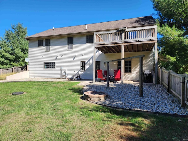 back of property featuring a patio, a lawn, a wooden deck, and a fire pit