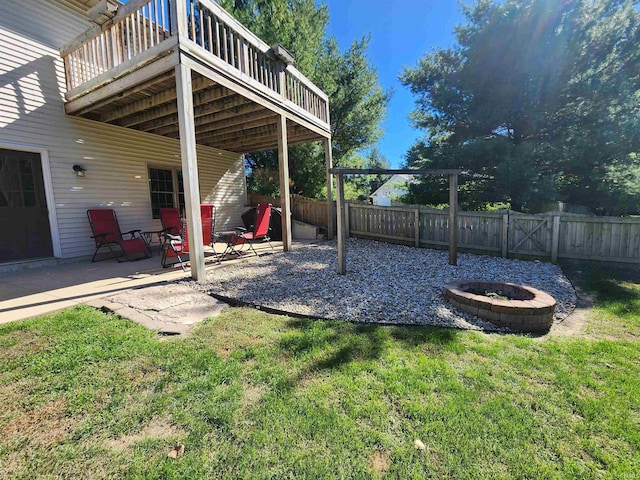 view of yard featuring a deck, a patio, and an outdoor fire pit