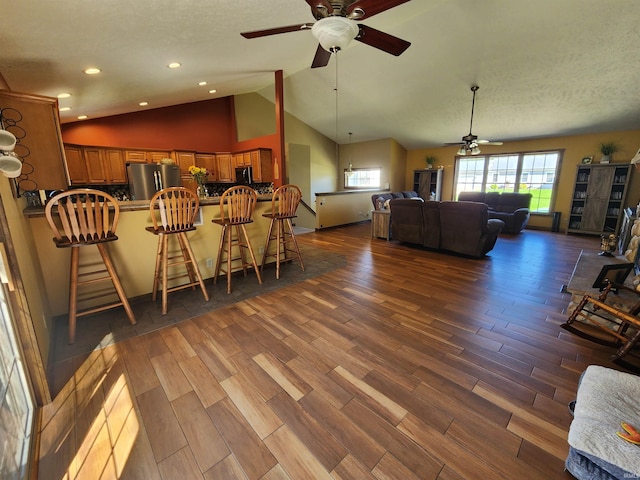 interior space featuring high vaulted ceiling, ceiling fan, hardwood / wood-style floors, and a textured ceiling