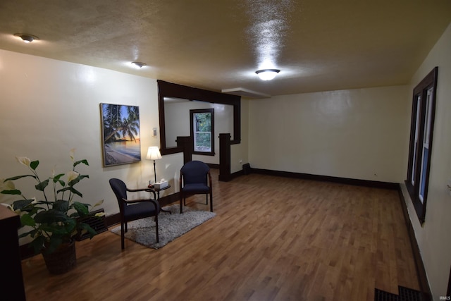 living area featuring wood-type flooring and a textured ceiling